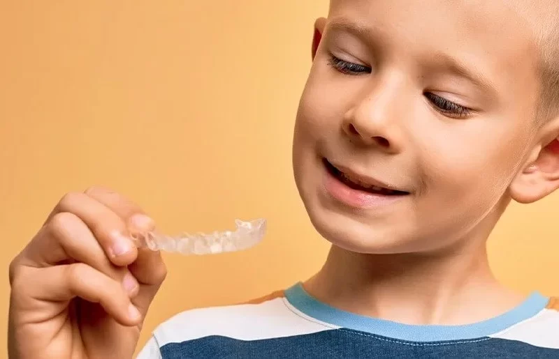 Αγόρι κρατάει Διάφανους νάρθηκες Invisalign First